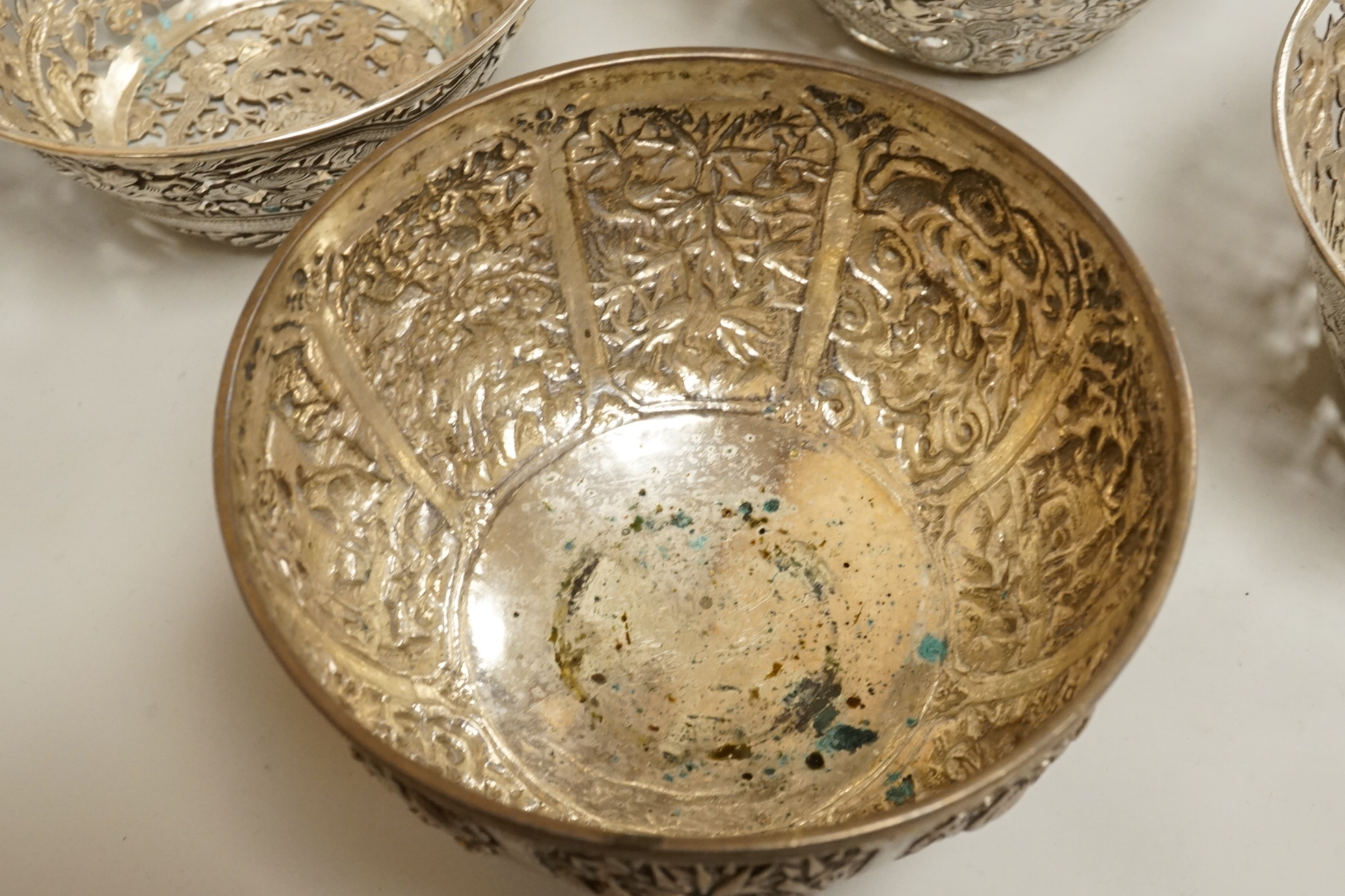 A set of three late 19th/early 20th century Chinese Export pierced white metal bowls, decorated with dragons, by Wang Hing, Hong Kong (lacking glass inserts?), diameter 12.5cm, together with one other similar Chinese Exp